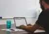 man sitting at the table while using laptop computer